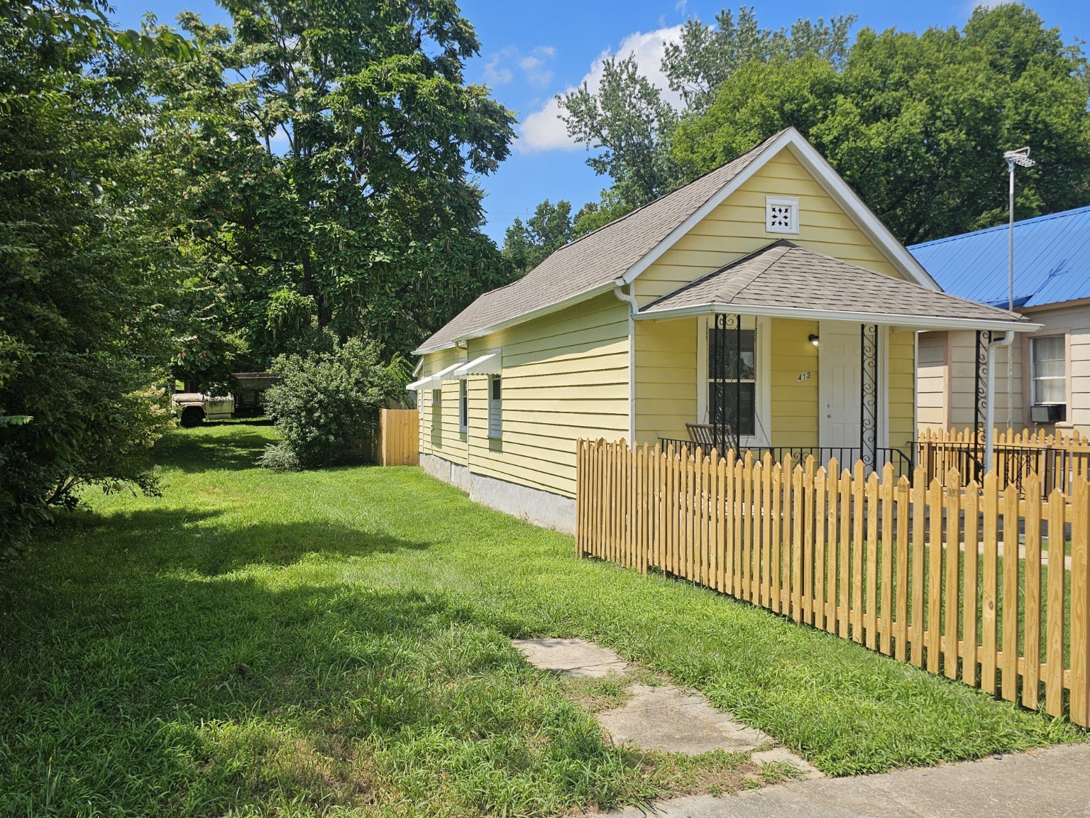 Front and side exterior of the yellow cottage